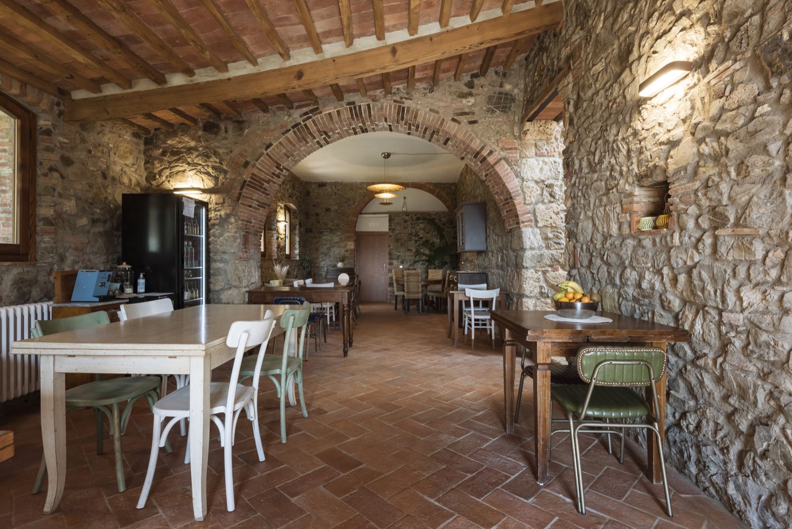 La sala del ristorante fra archi in pietra e cotto